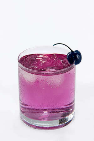 Drink with blue cherry and ice on white background. Studio shot.の写真素材