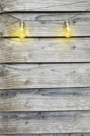 Outdoor string lights hanging on a line in fancy in backyard gardenの写真素材