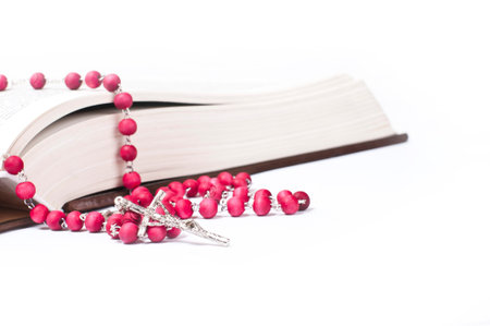 red rosary on a book  white background  studio shotの写真素材