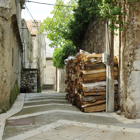 Senj, Croatia: a small town in northern Croatia, located on the Adriatic coast. Narrow street in the old town. Firewood gathered in front of the house.の写真素材