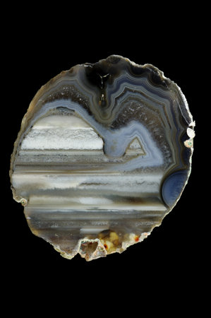 A cross-section of agate. Multicolored silica bands colored with metal oxides are visible....