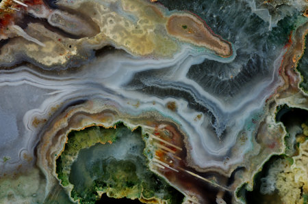 A cross-section of agate. Multicolored silica bands colored with metal oxides are visible....