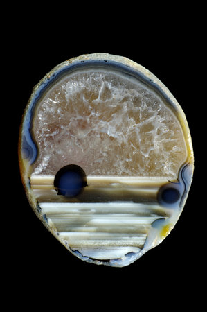 A cross-section of agate. Horizontal agate with quartz-agate fill. Multicolored silica rings colored...