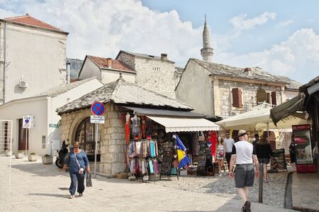 Mostar, Bosnia and Herzegovina - September 15, 2018: Old Town. You can see the architecture typical of the region, numerous souvenir and regional products shops . Tourists are walking along the street, in the background you can see the minaret tower.のeditorial素材