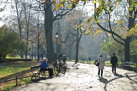 Cracow, Poland â November 07, 2018: Autumn in Planty Park, which surrounds the Old Town. You can see trees in autumn colors and people resting on benches or walking.のeditorial素材