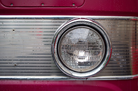 The headlamp on an old car, with raindrops.の写真素材