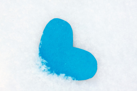 One heart shape from blue paper in the snow for Valentines dayの写真素材