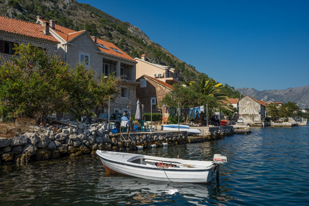 Muo, Montenegro â October 13, 2018: Rowing boat moored at the pier on the seafront in small adriatic town Muo near Kotor. View of the seafront of an adriatic town with its traditional small stone housesのeditorial素材
