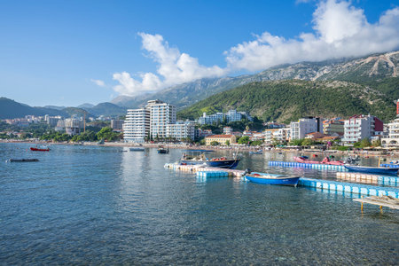 Rafailovici, Budva, Montenegro, October, 16, 2019: Aerial shot of an embankment of a seaside town with residential buildings and hotels, a pier with moored boatsのeditorial素材