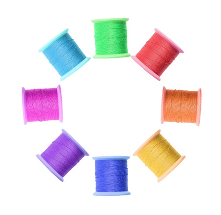 Few colorful thread bobbins isolated on white backgroundの写真素材
