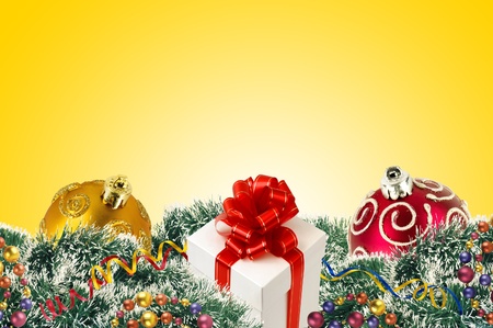 gift boxes and Christmas tree ornaments and Christmas tree branches and Christmas balls over yellow backgroundの写真素材
