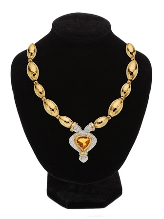Pendant with an orange gem on mannequin isolated on whiteの写真素材