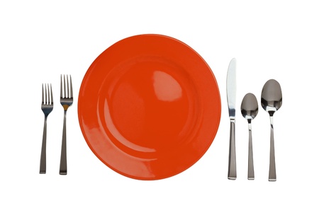 Red plate, forks, knife and spoons isolated on whiteの写真素材