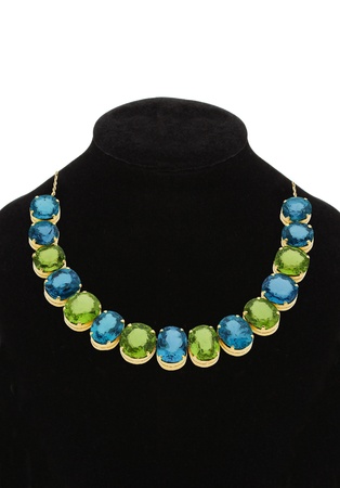 Pendant with green and blue gem stones on black mannequin isolated on white の写真素材