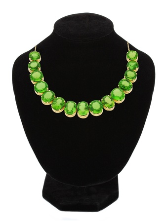 Pendant with green gem stones on black mannequin isolated on white の写真素材