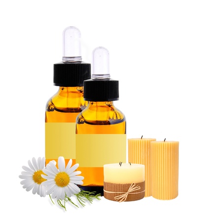 bottles with essence oil and chamomiles isolated on whiteの写真素材