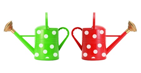 red and green polka dot watering cans isolated on whiteの写真素材