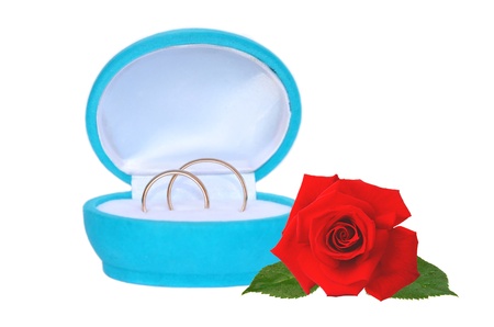wedding rings in blue gift box and red rose isolated on whiteの写真素材