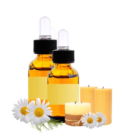 bottles with essence oil and chamomiles isolated on whiteの写真素材