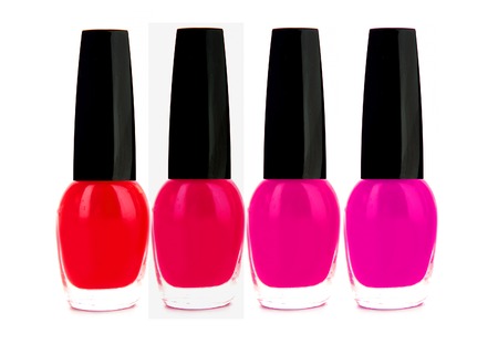 Nail polishes of red and pink color isolated on whiteの写真素材