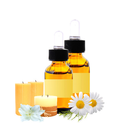 bottles with essence oil and chamomiles isolated on whiteの写真素材