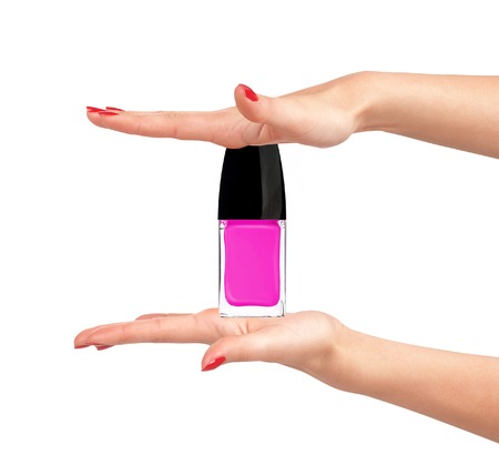 pink nail polish in woman hands on white backgroundの写真素材