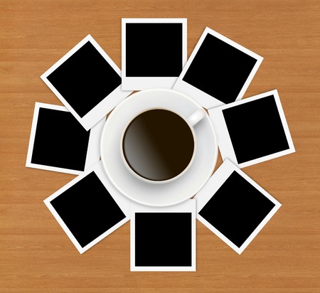 Photo papers and coffee cup on wooden backgroundの写真素材