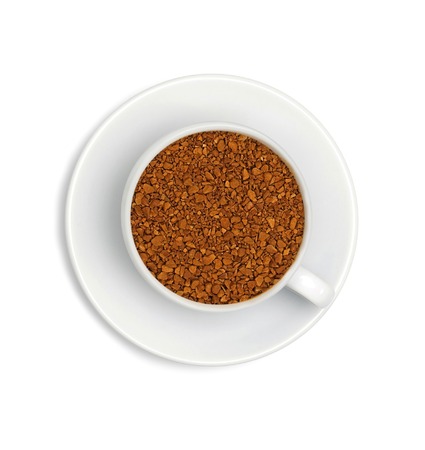 granules of instant coffee in a white cup and saucer isolated on white backgroundの写真素材