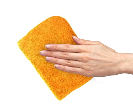 Hand wiping surface with orange rag isolated on whiteの写真素材