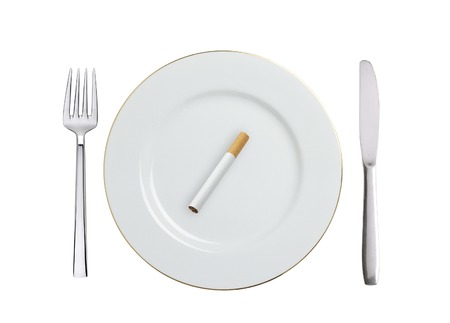cigarette on white plate isolated on white backgroundの写真素材