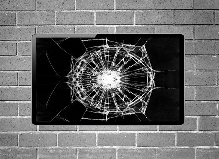 Blank screen LCD tv with broken screen hanging on a wallの写真素材