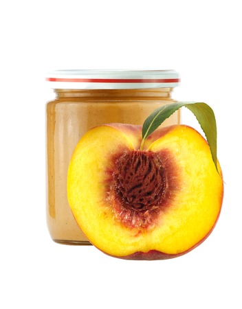 Jar of baby puree and half of fresh peach isolated on whiteの写真素材