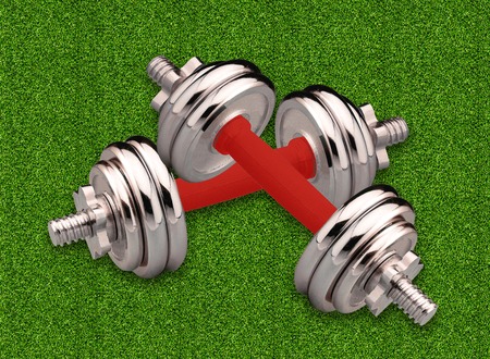 Couple of metal dumbbells over green grassの写真素材