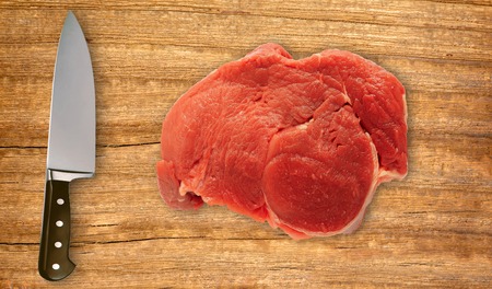 knife on cutting board and fresh meat isolated on white backgroundの写真素材
