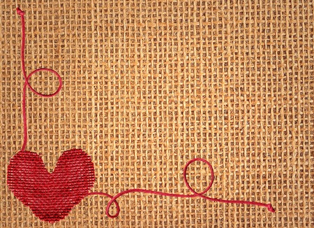 Red heart over linen texture backgroundの写真素材