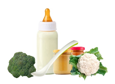fresh cabbage, baby food, spoon and and milk bottle isolated on white backgroundの写真素材