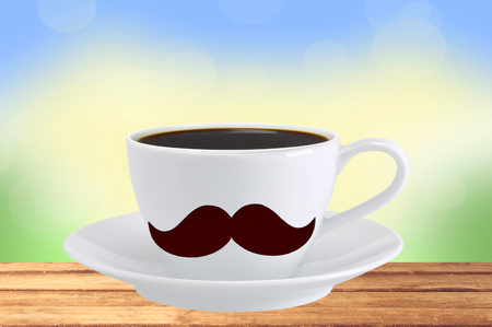 white cup of coffee on wooden tableover nature backgroundの写真素材