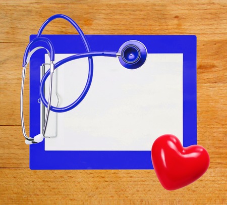 stethoscope, red heart and blue clipboard over wooden backgroundの写真素材