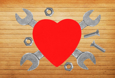 Heart and tools. Concept: Renovation of heart. Over wooden backgroundの写真素材