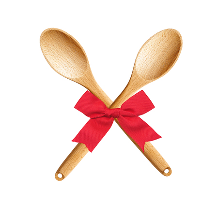 Wooden Kitchen Spoons with red bow isolated on white backgroundの写真素材