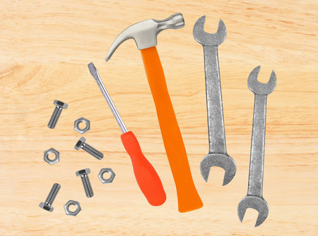 Hammer, screwdriver and wrenches on wooden table background