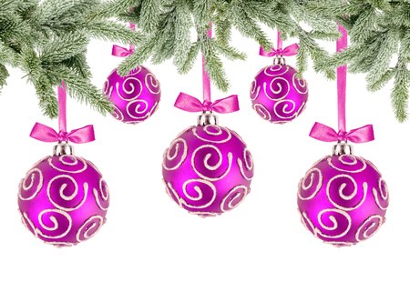 Pink Christmas balls with bows and christmas tree branches on white backgroundの写真素材