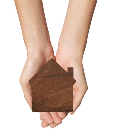 Female hands holding model of house isolated on white backgroundの写真素材