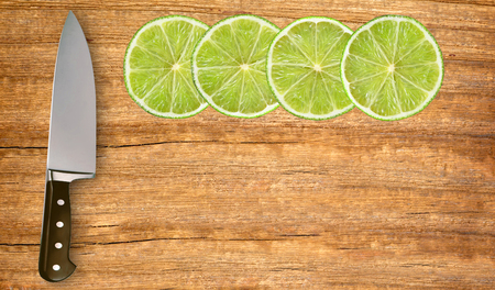 lime slices and knife on cutting board isolated on white backgroundの写真素材