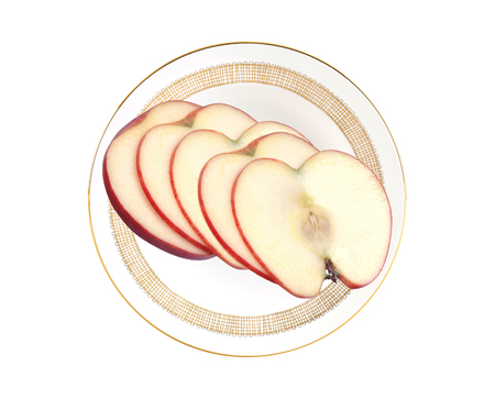 Sliced apple on white plate isolated on white backgroundの写真素材