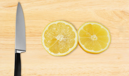 lemon and knife on cutting board isolated on white background