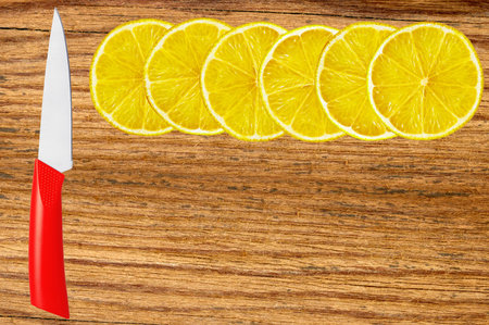 knife and lemon slices on cutting boardの写真素材