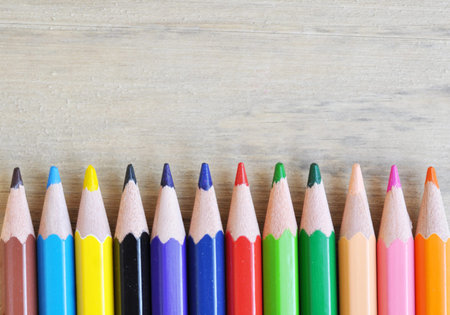 close up stack colour pencils on wooden background