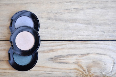 eyeshadows in black boxes and brush on wood tableの写真素材
