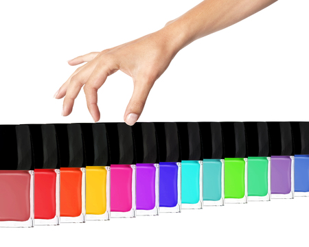 Group of bright nail polishes and woman hand isolated on white backgroundの写真素材